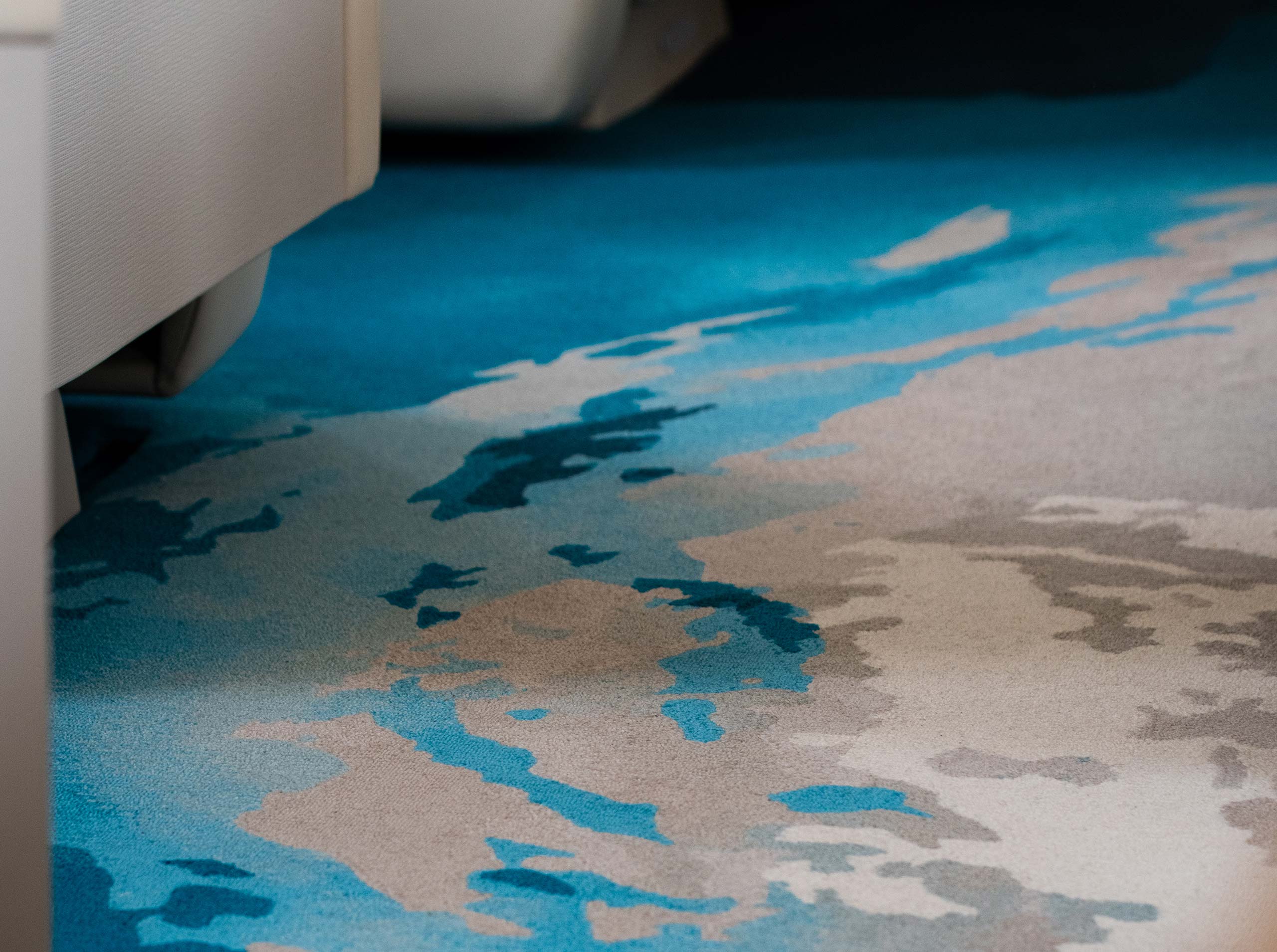 Nahaufnahme des Teppichs in der Kabine einer Global 6000 mit organischem Farbverlauf in Blau-, Beige- und Sandtönen