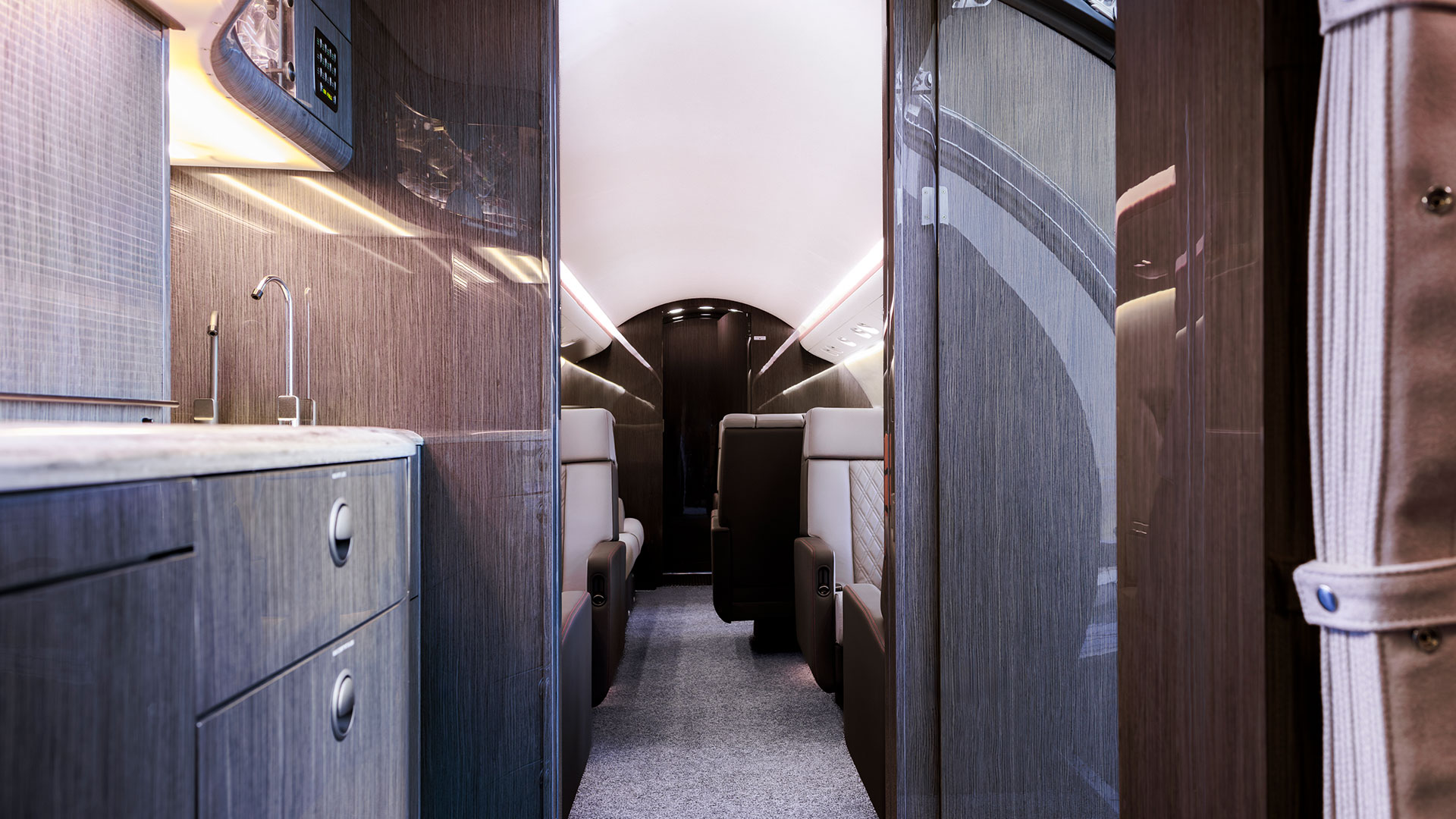 Blick durch die Galley einer Challenger 604 mit modernen Furnieroberflächen und Sicht auf Kabinensitze im Hintergrund
