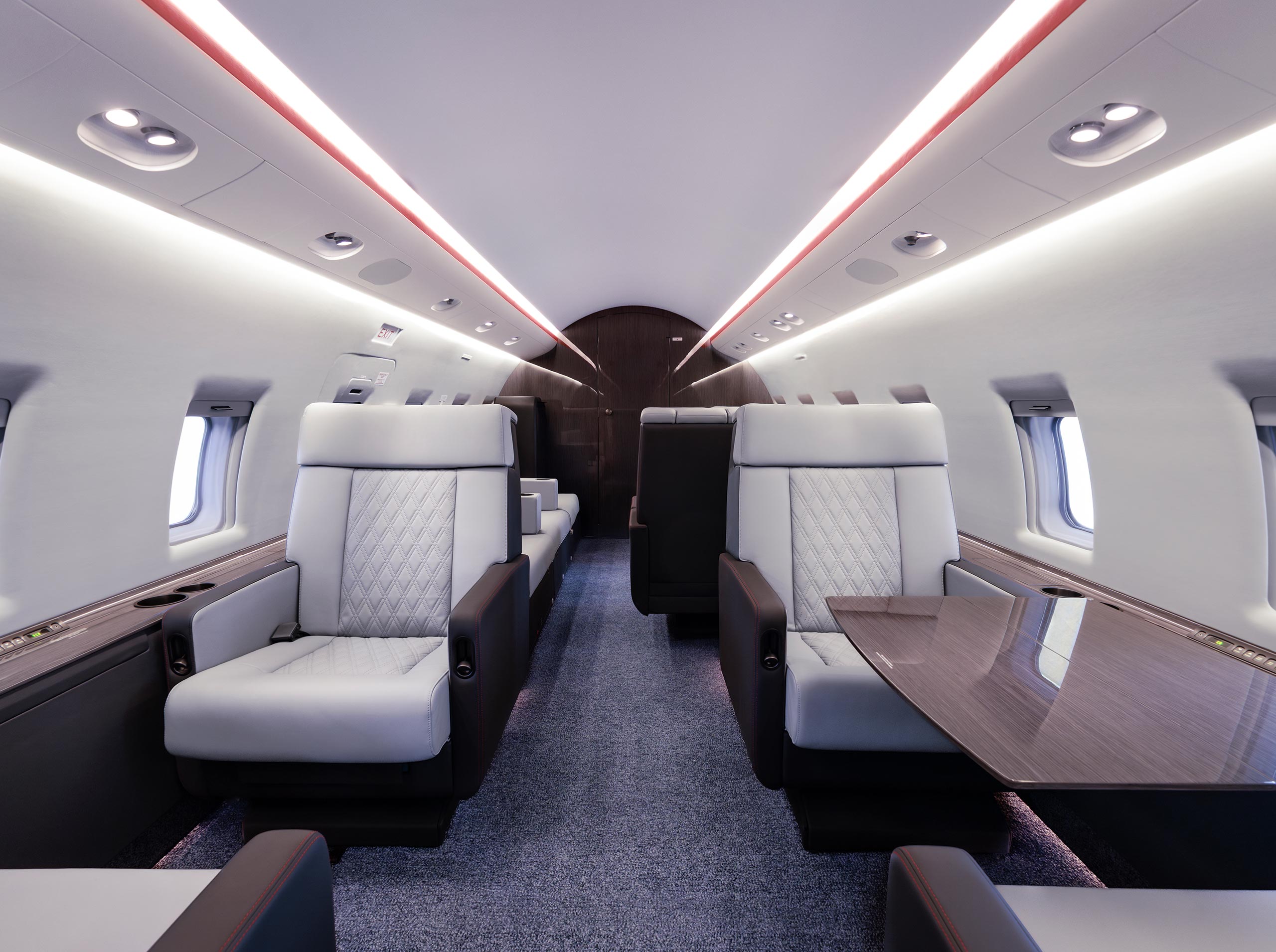 Kabinenaufnahme einer komplett überarbeiteten Challenger 604 mit neuen Sitzen, furniertem Klapptisch, Sidewalls und Teppich in Blautönen
