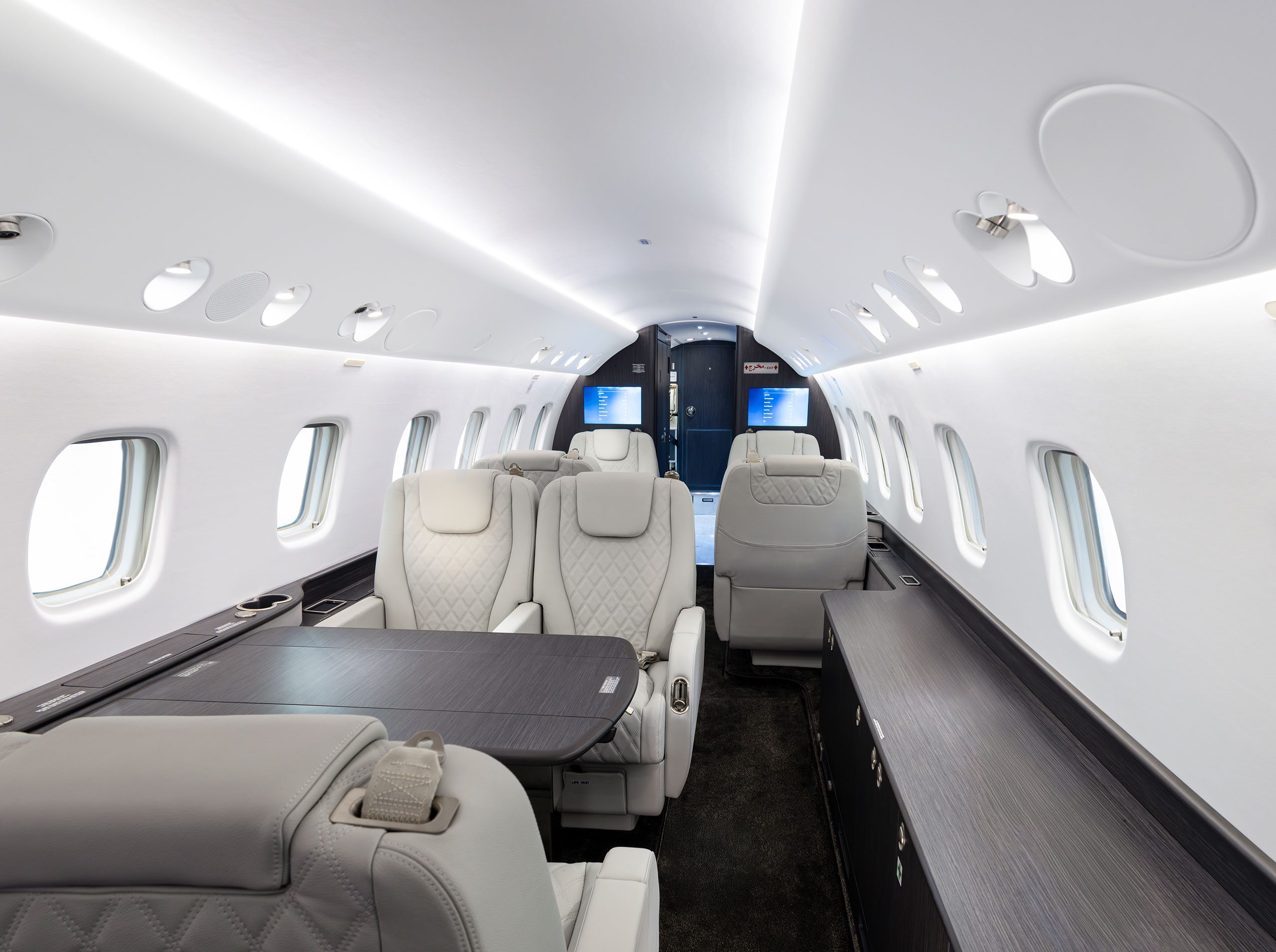 Kabinenansicht einer vollständig überarbeiteten Legacy 650 mit hellgrauen Ledersitzen, rautenförmiger Steppung, dunklem Furnier und modernem Decken- und Beleuchtungskonzept